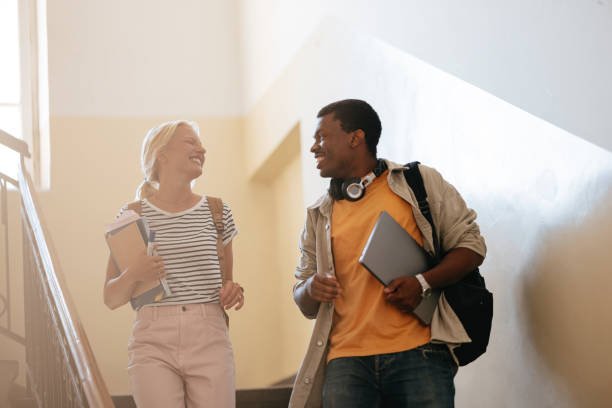 istock Happy Students Walking Together at University Campus Stairs 2167617634