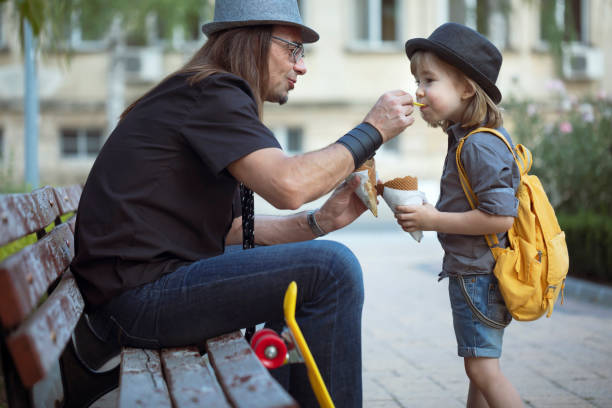 istock Middle-aged father and his cute kid create priceless moments together while eating ice cream outside 2167619700