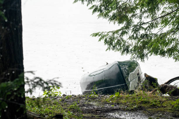 istock Canoe under the rain by a lake in the forest 2167622704