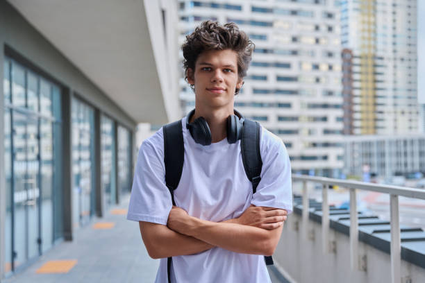 istock Handsome young man looking at camera outdoors, modern skyscrapers urban style background 2167623355