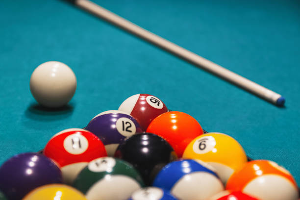 istock Colorful billiard balls with numbers with cue sticks and rack on blue table 2167624113