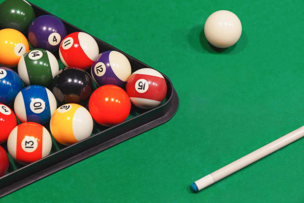 Colorful billiard balls with numbers with cue sticks and rack on blue table