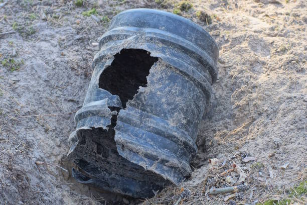 istock one big old broken black plastic barrel with a hole lies 2167629094