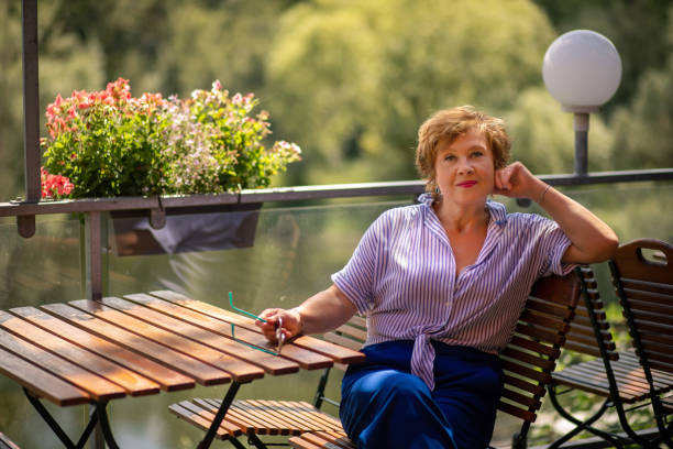 istock Woman relaxing on a balcony surrounded by greenery during a sunny afternoon 2167630325