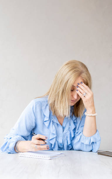 istock Tired woman touching forehead having headache migraine. Vertical shot 2167631847