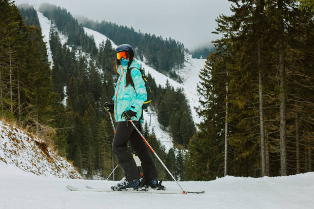 istock Female skier on a slope through the forest in Alps 2167645008
