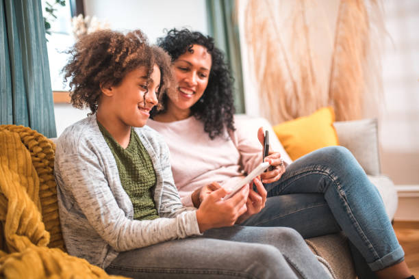 istock Shared Reading Experience: Hispanic Mother and Mixed Race Daughter 2167645137