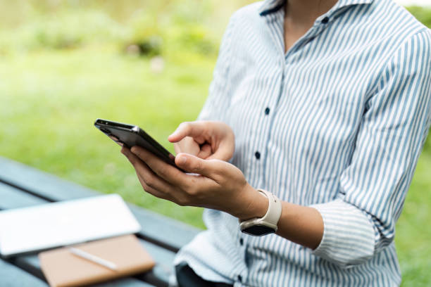 istock young student studying outdoors, holding a mobile and sitting at university park 2167667843