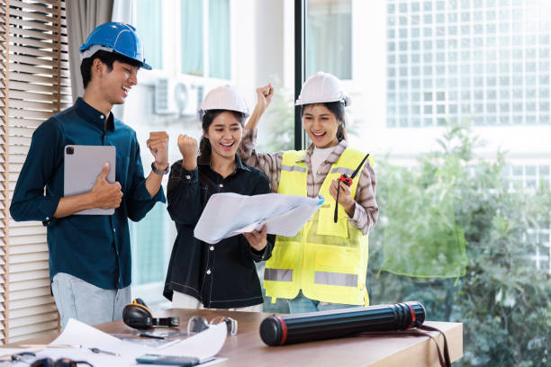 istock Group of Engineers Celebrating Success with Blueprint in Modern Office Setting 2167668035