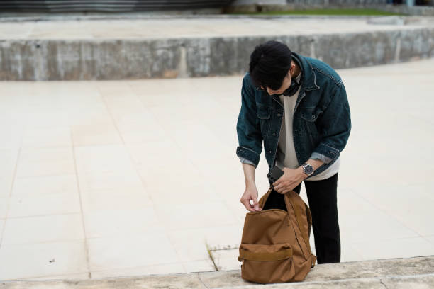 istock Young Traveler Preparing Backpack for Adventure in Urban Setting 2167668227