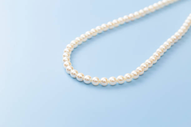 istock Pearl necklace on a blue background 2167668943