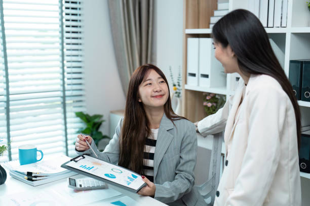 istock Professional Businesswomen Discussing Financial Reports in Modern Office Setting 2167670357