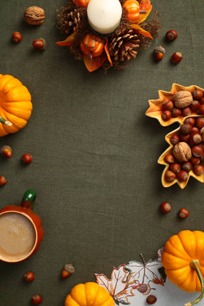 istock Autumn flat lay composition, with copy space on green textile background. Top view frame of pumpkins, nuts, coffee cup, candle. 2167703742