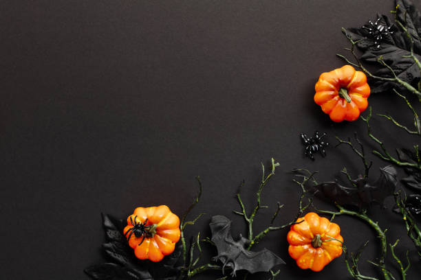 istock Spooky Halloween background. Flat lay pumpkins, scary bats on branches, dark maple leaves on black table, top view. 2167704880