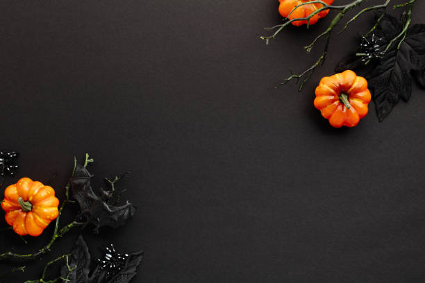 istock Spooky Halloween flat lay composition with pumpkins, maple leaves, branches on dark background. Top view with copy space. 2167705134