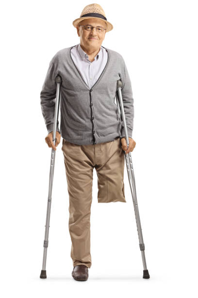 Elderly man without leg standing with crutches and smiling at the camera isolated on white background