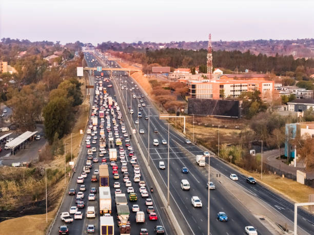 Cars stuck in a congested city street during sunset, highlighting urban transportation challenges
