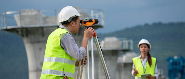 istock Survey team is working with a theodolite and road construction plans. Civil engineers are taking measurements with surveying tools during the construction. 2167707793