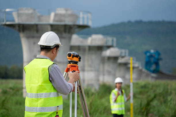 istock Survey team is working with a theodolite and road construction plans. Civil engineers are taking measurements with surveying tools during the construction. 2167708603