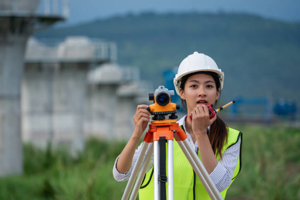 istock Construction workers wearing a safety vest and a hard hat is holding a surveying instrument 2167708793
