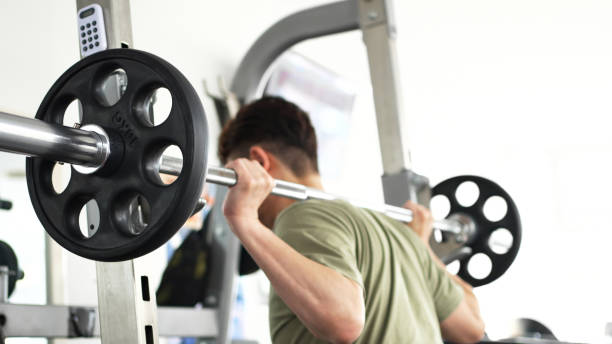 Man training his lower body with barbell squats stock photo