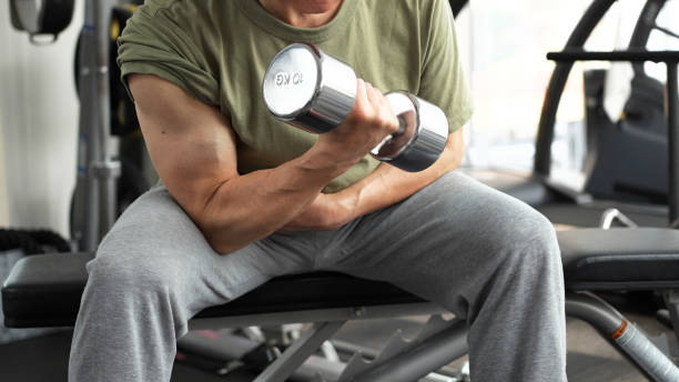 Man training his arms with dumbbell arm curls stock photo