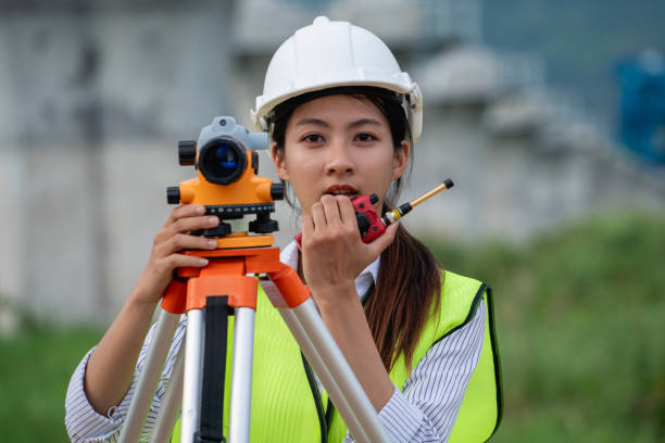 istock Construction workers wearing a safety vest and a hard hat is holding a surveying instrument 2167710041