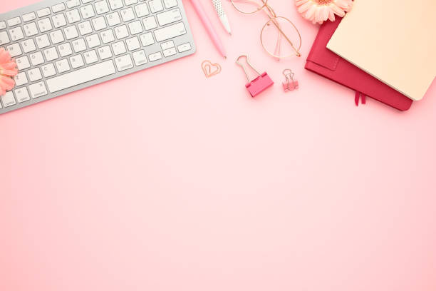 istock Flat lay modern workspace with office supplies on pastel pink background. Top view keyboard, glasses, paper notebooks, clips. Education, distance work concept. 2167710142