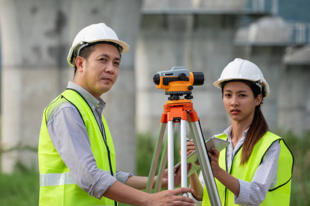 istock Two construction workers wearing safety gear and holding a measuring device 2167710460