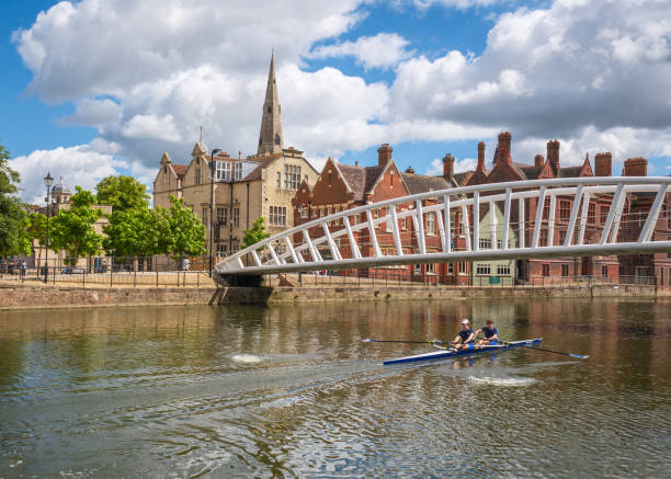 Bedford, England - 8th July 2024: Two rowers training in a double scull pass under the Riverside Bridge over the river Great Ouse in the town of Bedford in Bedfordhire, England