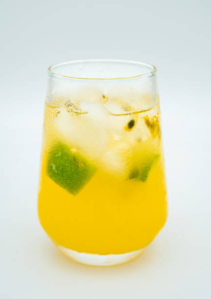 A glass of refreshing and cold lemon and orange juice with ice cubes in it, showing a natural yellow hue. There are water droplets on the surface of the drink, which adds a cool feeling in the summer. This drink is suitable for healthy drinks and summer cooling photography.