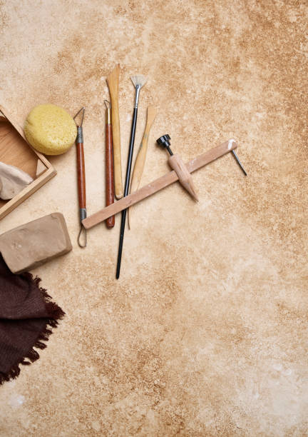 istock Making ceramic, women's hands and tools on the decorative table style background, up view. 2167717481