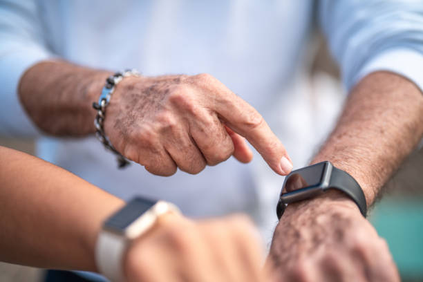 istock Senior Hispanic Man and Adult Daughter Using Smartwatch Post-Exercise 2167723125