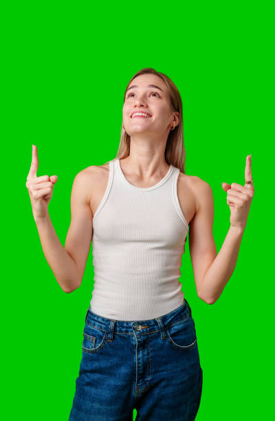 istock Young Woman Pointing Upwards Against Green Screen Background 2167723575
