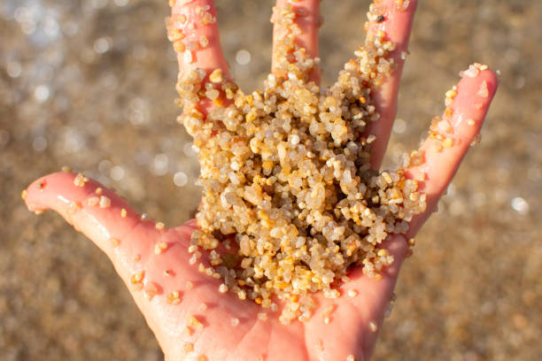 Woman pouring sand on tropical beach in summer