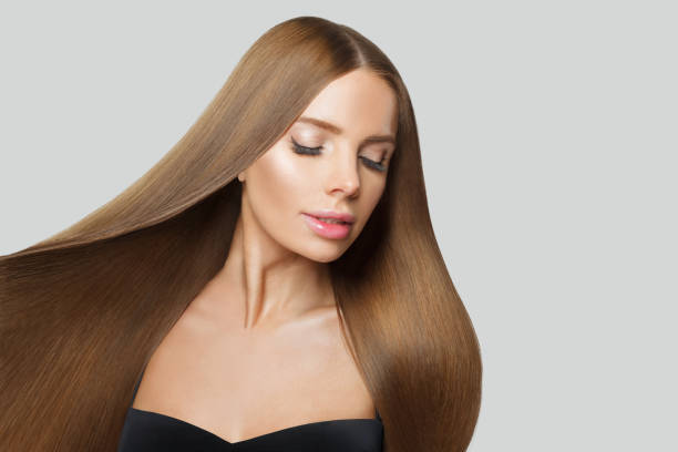 istock Glorious young woman model with modern make-up and long straight smooth hairstyle standing on white studio background 2167725841