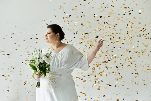 Elegant plus-size bride in a stunning gown, surrounded by confetti on grey