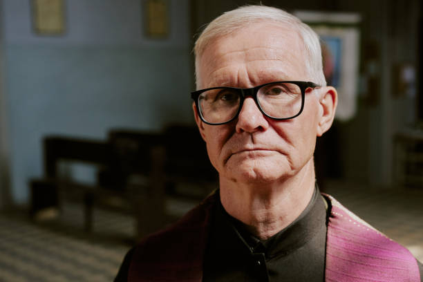 Medium close up portrait of gray-haired pastor with black glasses