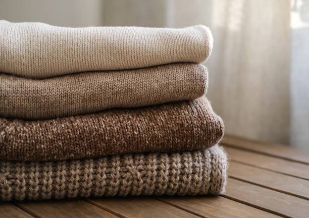 istock Stack of knitted clothes in beige and brown colors 2167750824