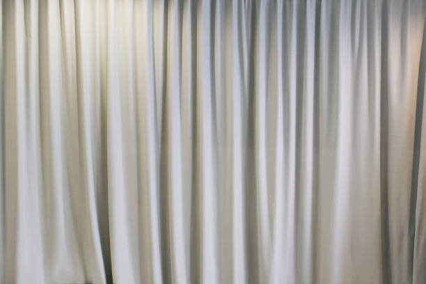 istock white curtain that dropped down as a straight line. Background for inserting text, empty spaces 2167752228