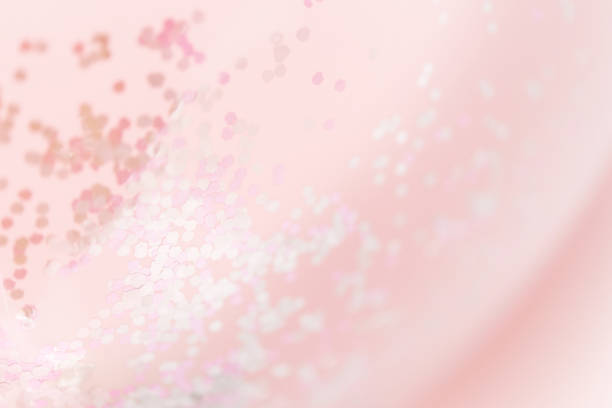 Pink blurred background with glitter confetti, pastel rose pink color