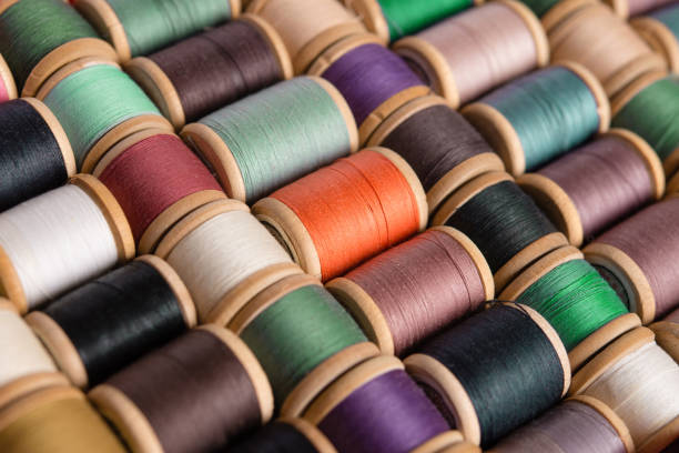 pile of rolls of colorful sewing thread with copy space isolated on white background