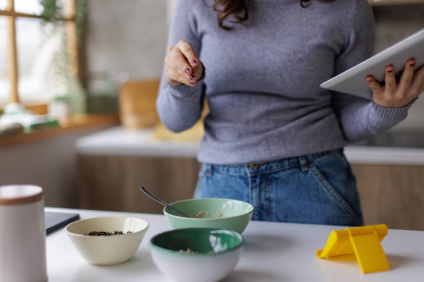 istock Young woman making herself breakfast and using a tablet 2167752725