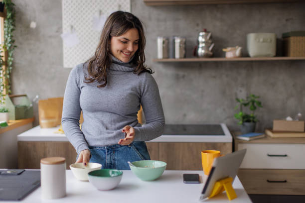 istock Young woman making herself breakfast and using a tablet 2167752771