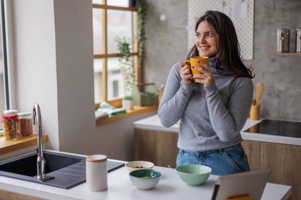 istock Young woman drinking coffee at home 2167752778