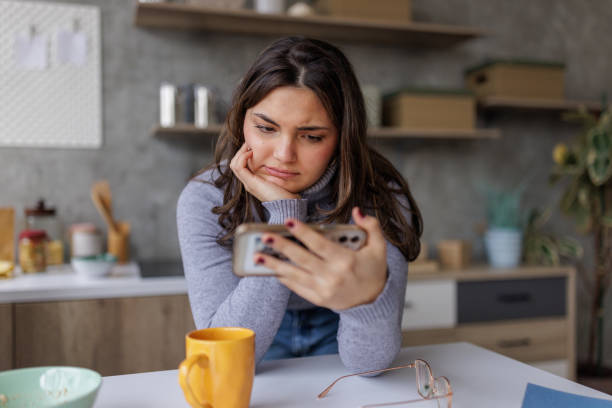istock Young distressed woman using her phone at home 2167753375