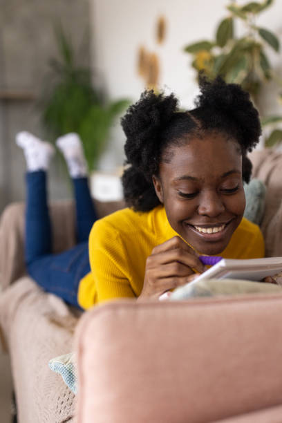istock Young woman writing in a notebook at home 2167753429