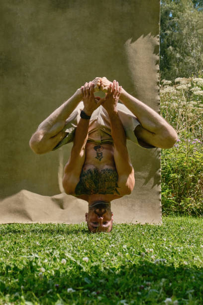 Man doing Yoga, headstand in a nature and studio background. Hip-hop dancer in a nature. Male dancing outdoors. Shallow depth of field