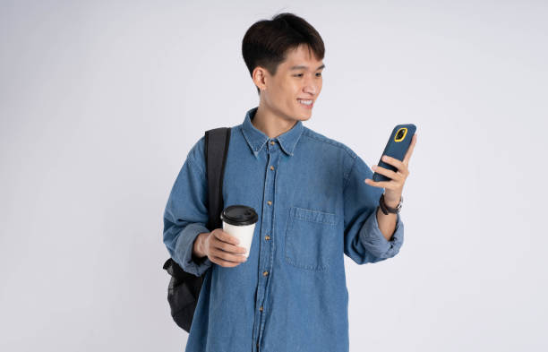 istock Portrait of Asian male student using phone on white background 2167757700