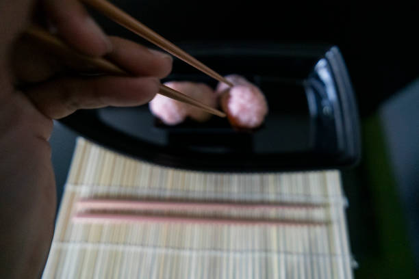 Holding sushi roll with chopsticks